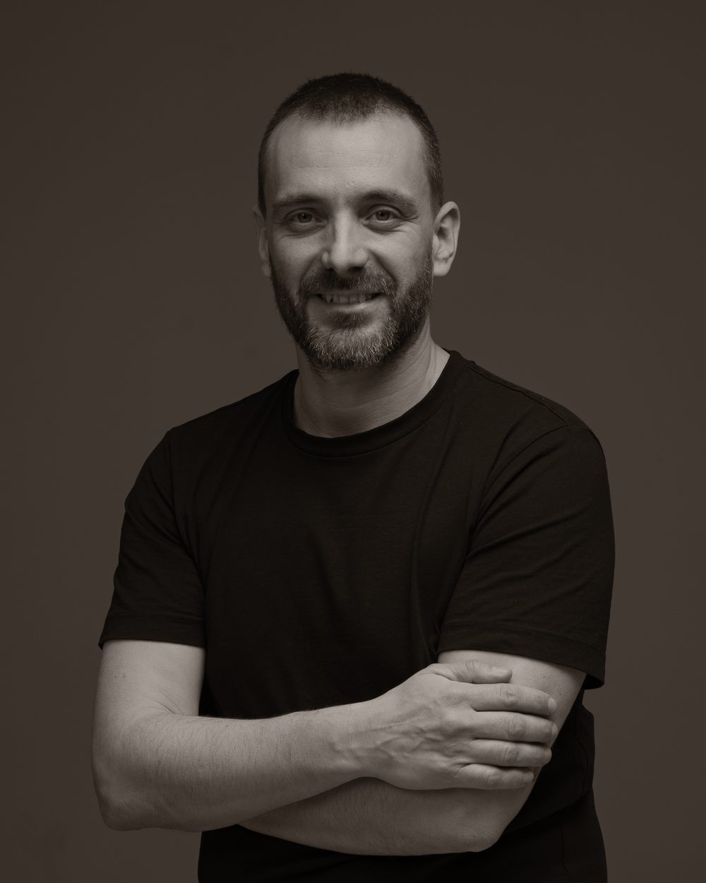 Albert Domènech, psicòleg general sanitari, somrient amb els braços plegats